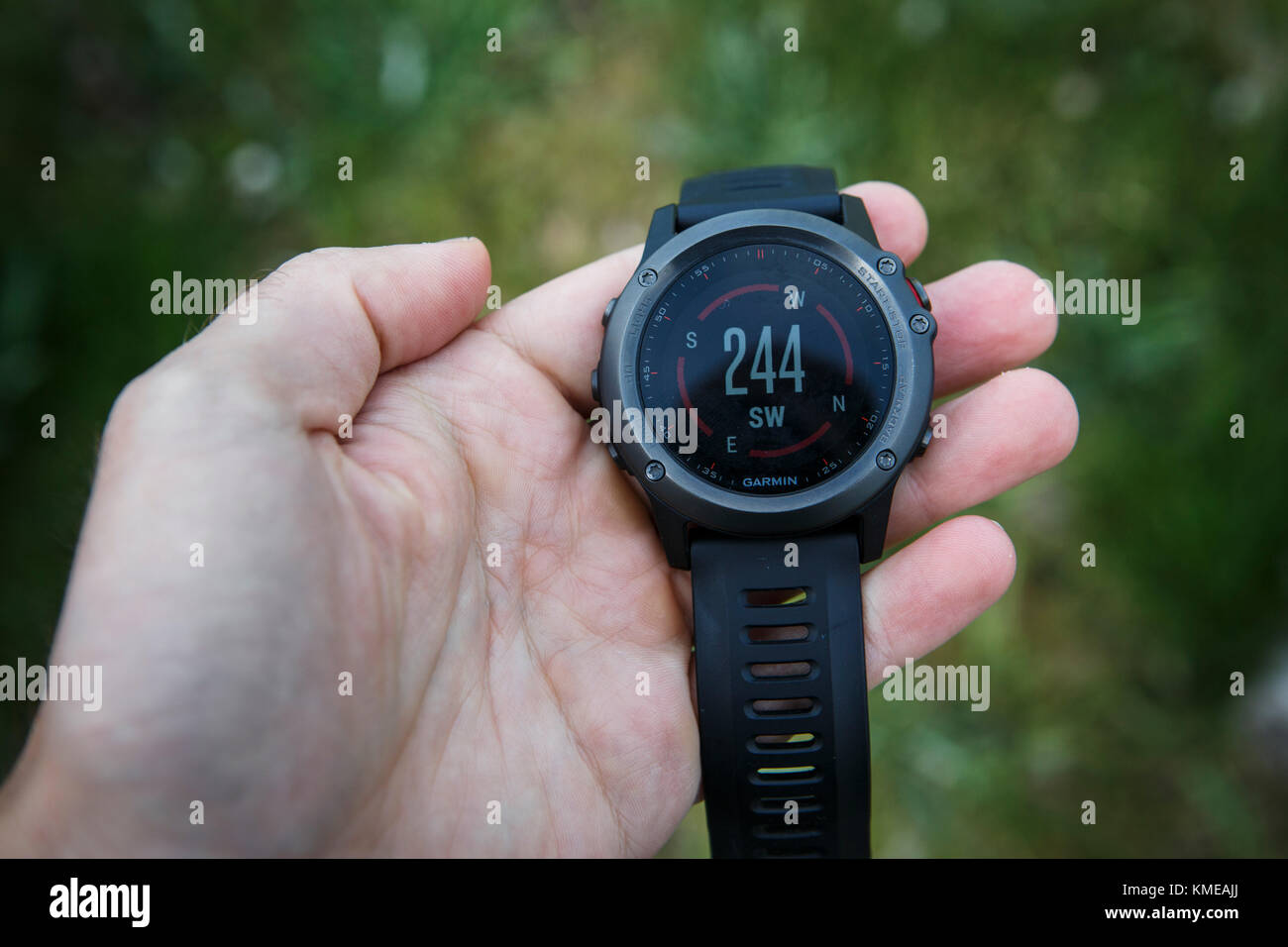 Hand of person holding wristwatch with GPS compass, Colorado, USA Stock Photo