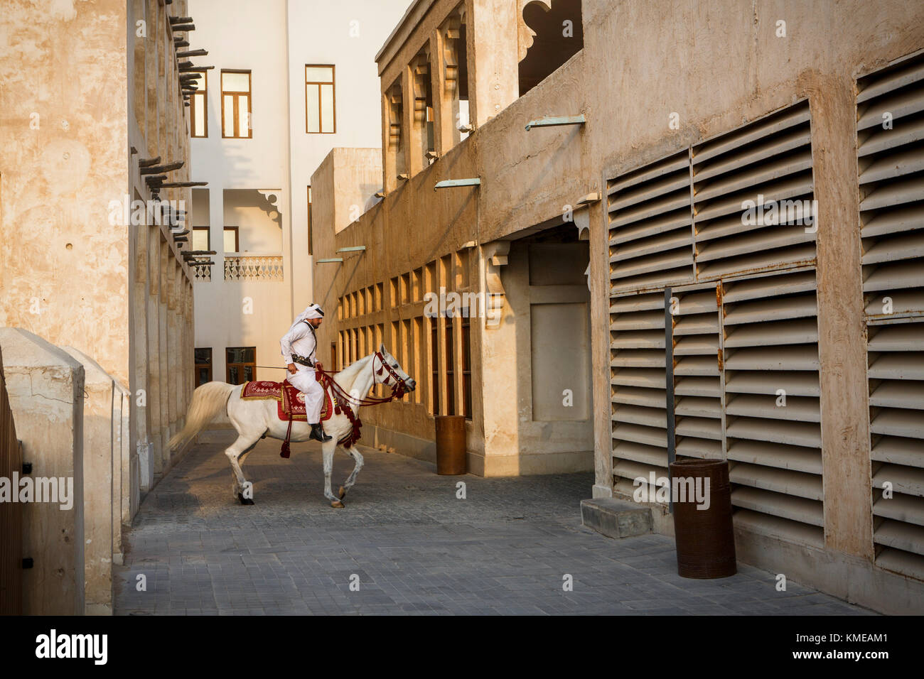 Man in traditional Arabic clothing riding horse at Souq Waqif,Doha,Qatar Stock Photo