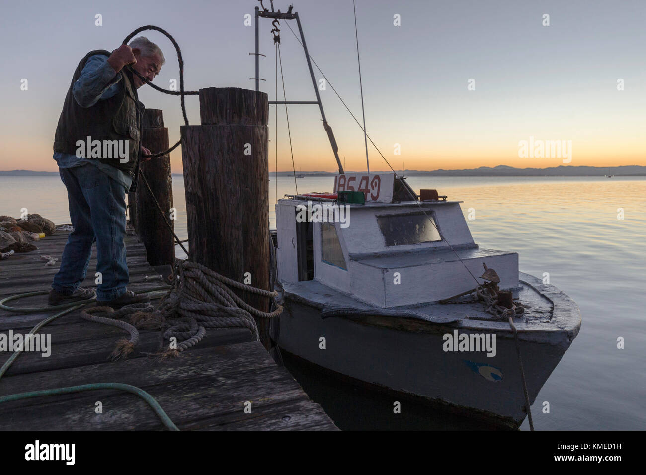 shrimp fisherman standing on pier near boat at sunset,China Camp,California,USA Stock Photo