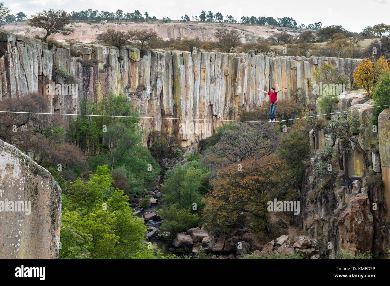 Person balancing on rope hanging across canyon cliffs,Aculco,State of Mexico,Mexico Stock Photo