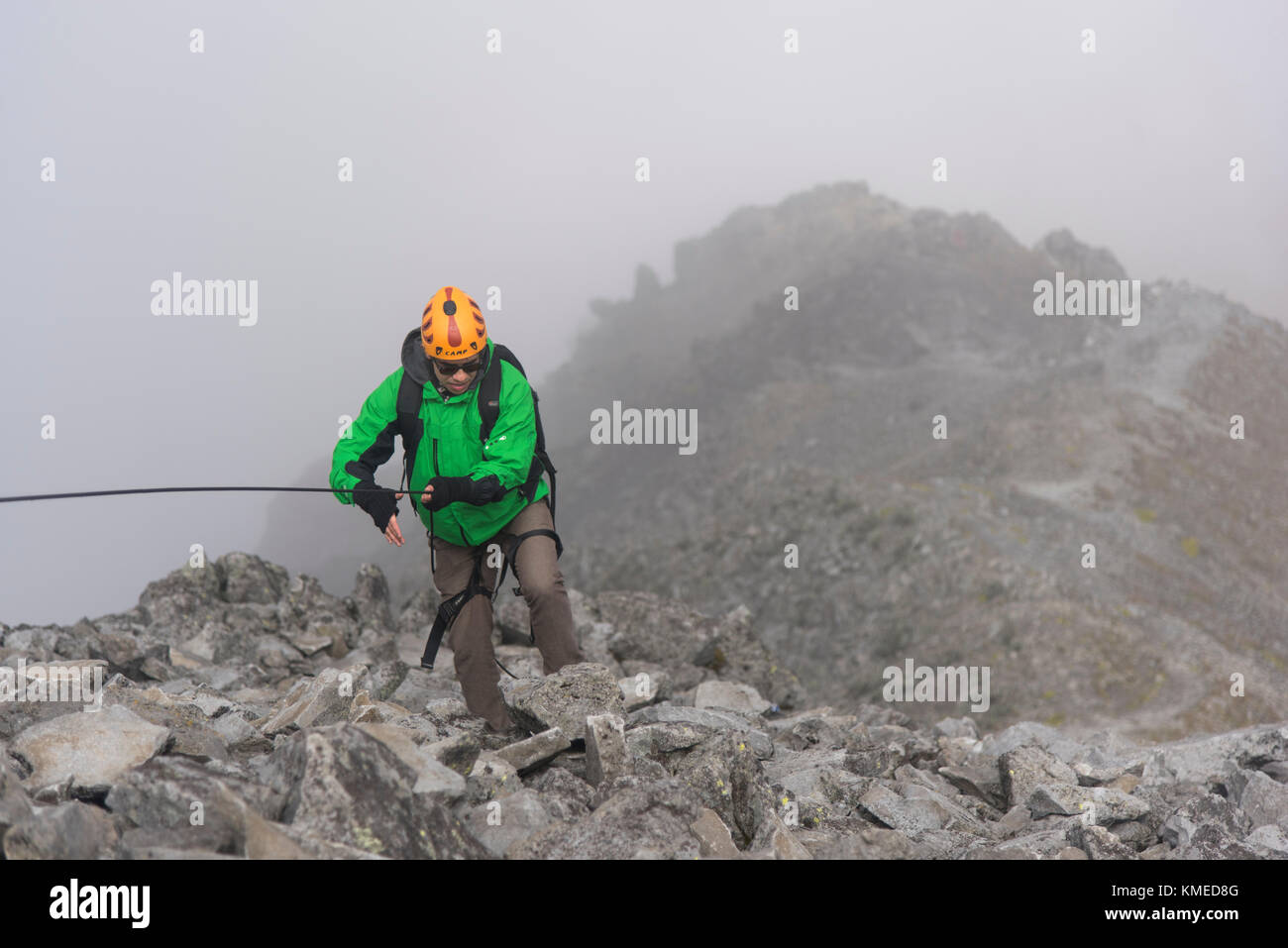 One climber holding a rope on a rocky section while hikking up at the Nevado de Toluca volcano in Estado de Mexico, Mexico. Stock Photo
