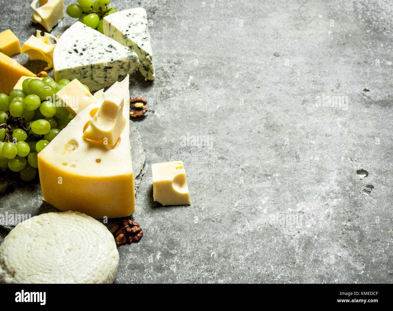 Different cheese , grapes and nuts. On the stone table. Stock Photo