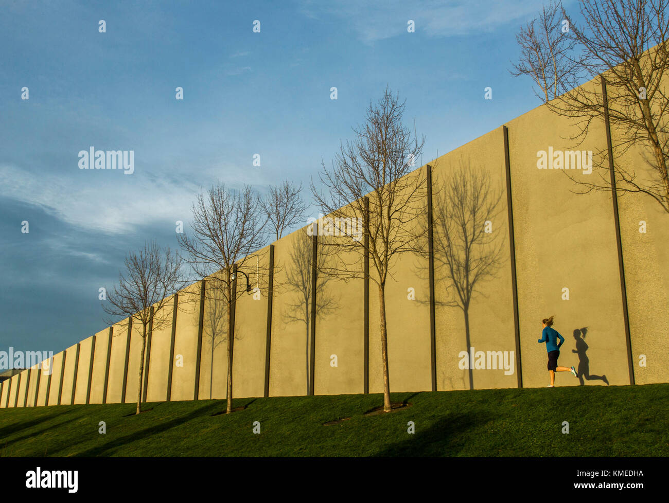 A runner jogs along the edge of a wall near Seattle's Sculpture Park. Stock Photo