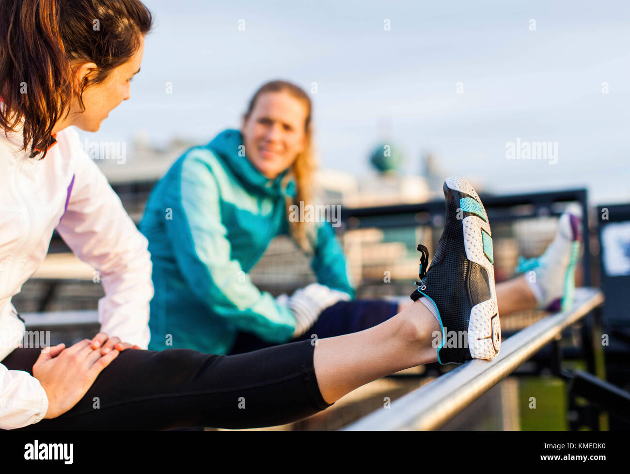Two female runners stretch their hamstrings after a job near the Puget Sound in Seattle, WA. Stock Photo