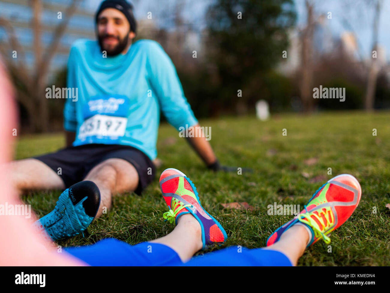 A view of a runner from the point of view of another resting in the grass in Seattle, WA. Stock Photo