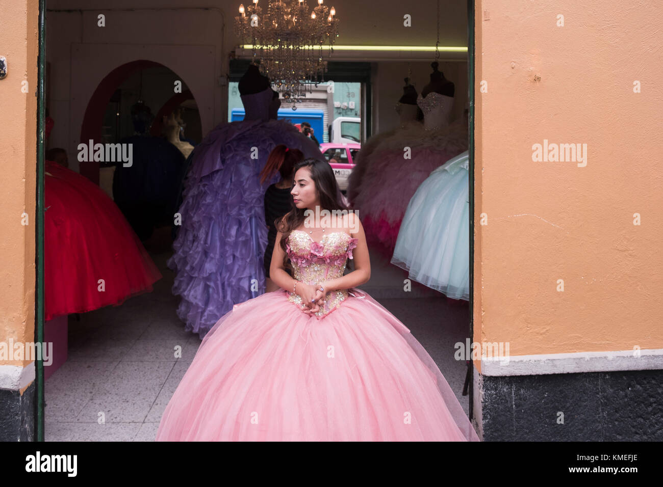 Teenage girl posing in quinceanera dress outside shop, Mexico City, Mexico Stock Photo