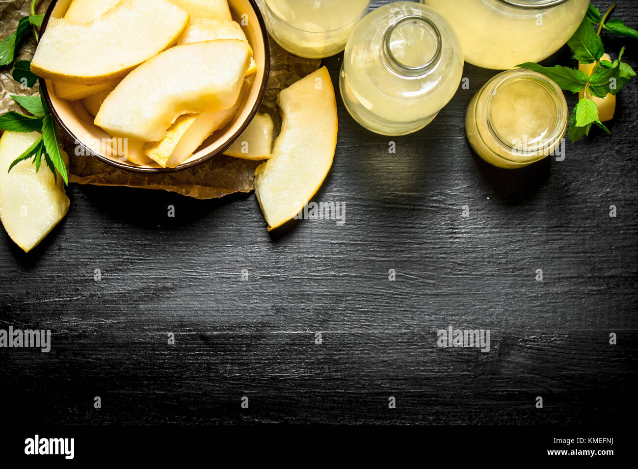 Fresh juice of a melon with branches of fresh mint. On the black wooden table. Stock Photo
