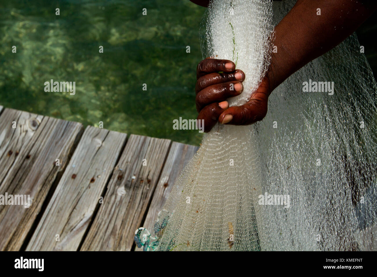 Close up of hand of man holding fishing net, Isla Marisol, Belize Stock Photo