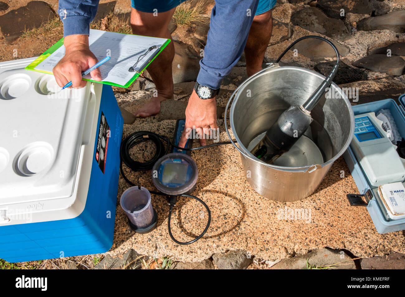 Wataru Kumagai of the State of Hawaii Department of Health Clean Water Branch,demonstrates water sampling of Hawaiian beaches at Ala Moana Beach in Honolulu using instruments such as a turbidity meter.For the full scope of readings,lab work has be done offsite. Stock Photo