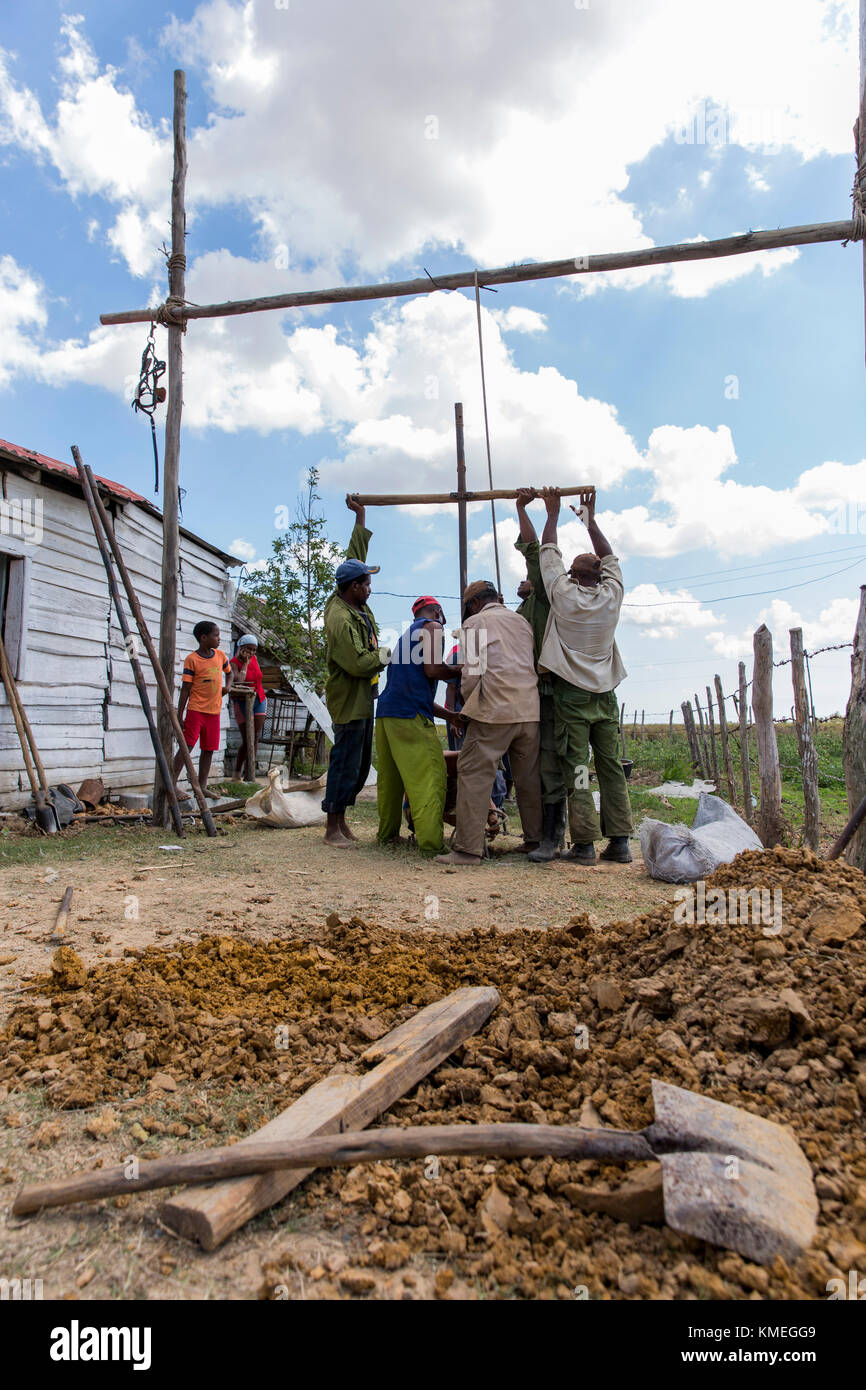 A group of men dig a well outside their home in Boca de San Diego, Cuba. Stock Photo