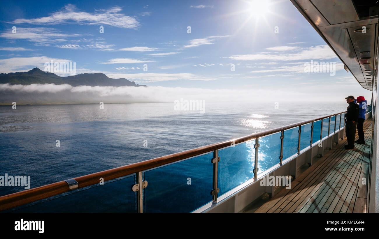 Two ship passengers looking at view of east coast of Iceland Stock Photo