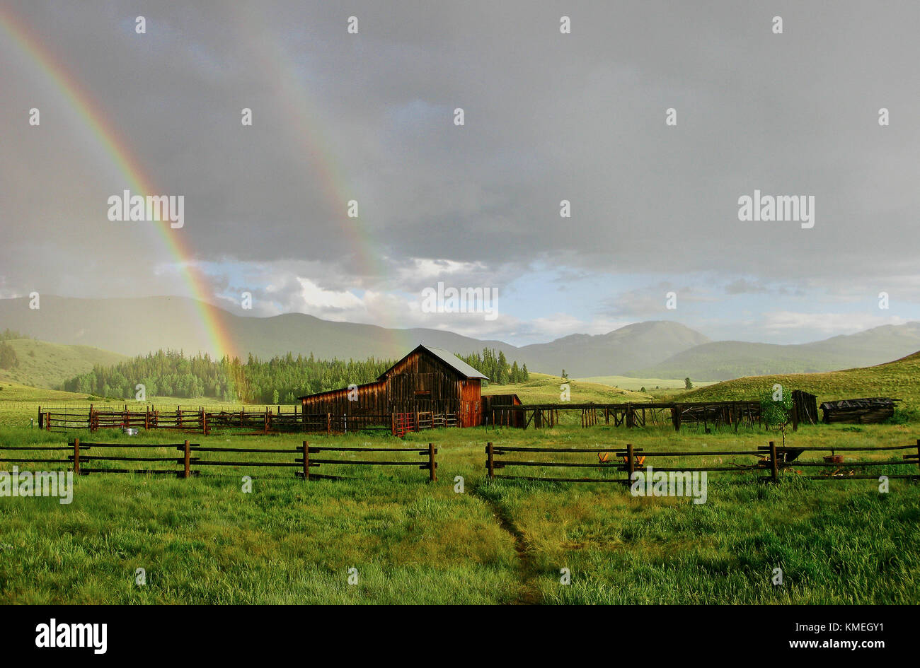 Old barn and rainbow after rainstorm, Creed, Colorado, USA Stock Photo