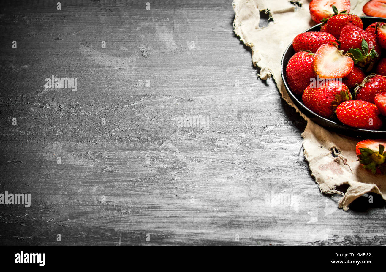 Ripe strawberries old plate. On the black wooden table Stock Photo - Alamy