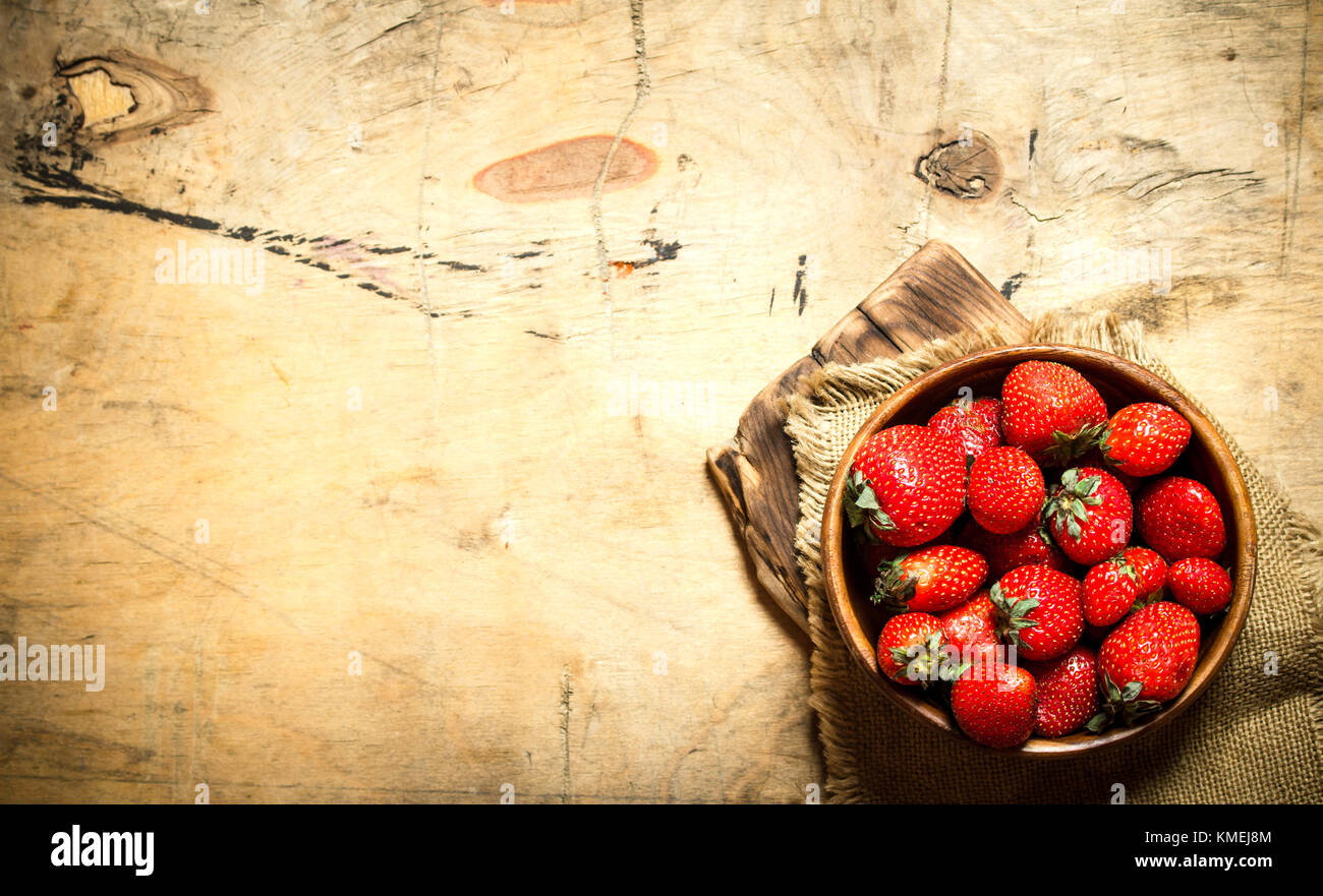 Ripe strawberries in bowl on Board. On wooden background Stock Photo ...