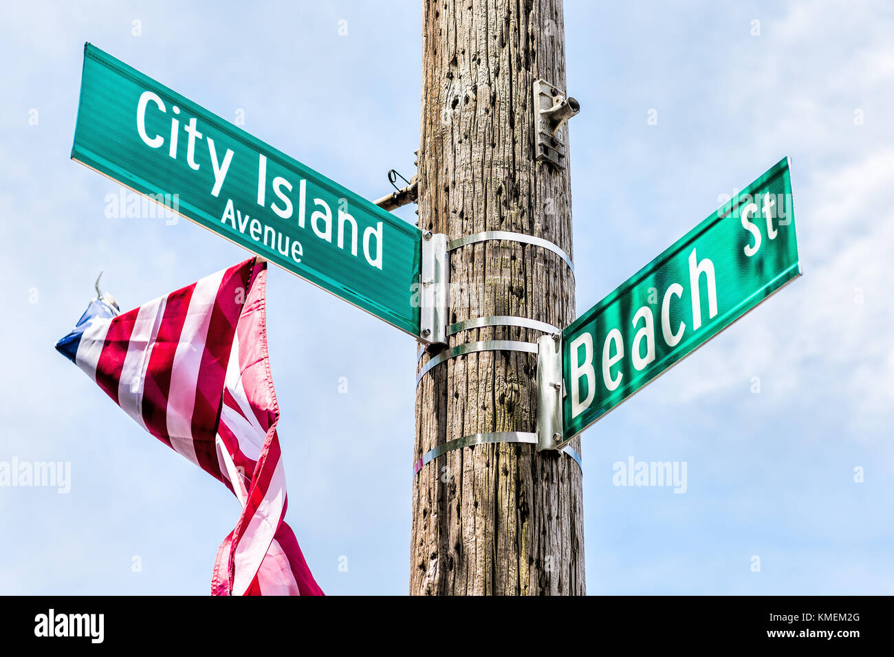 City Island Avenue and Beach street signs at intersection in Bronx, New York City, NYC with american flag Stock Photo