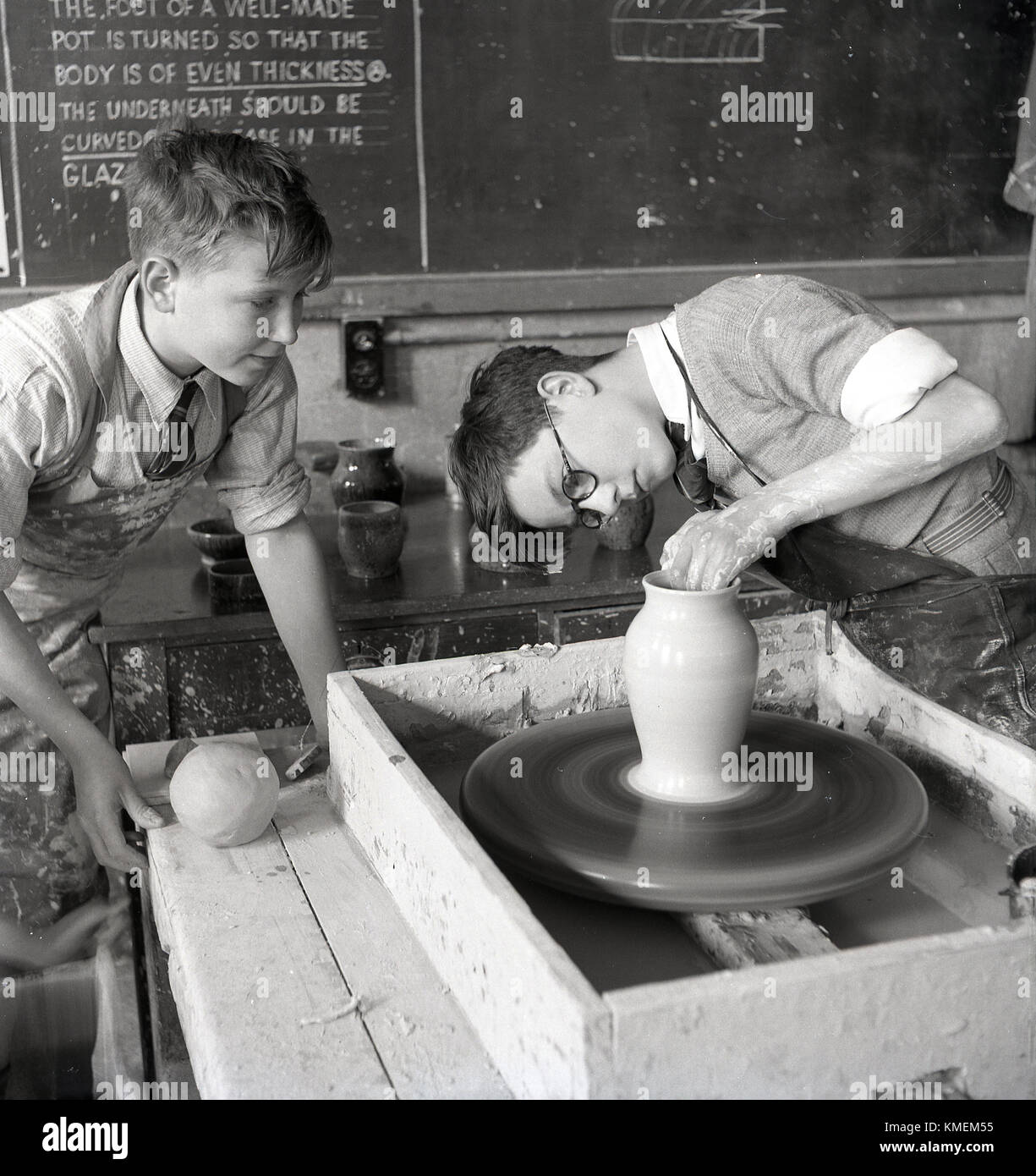 1950s, historical, school pottery class, two young boys in a classroom