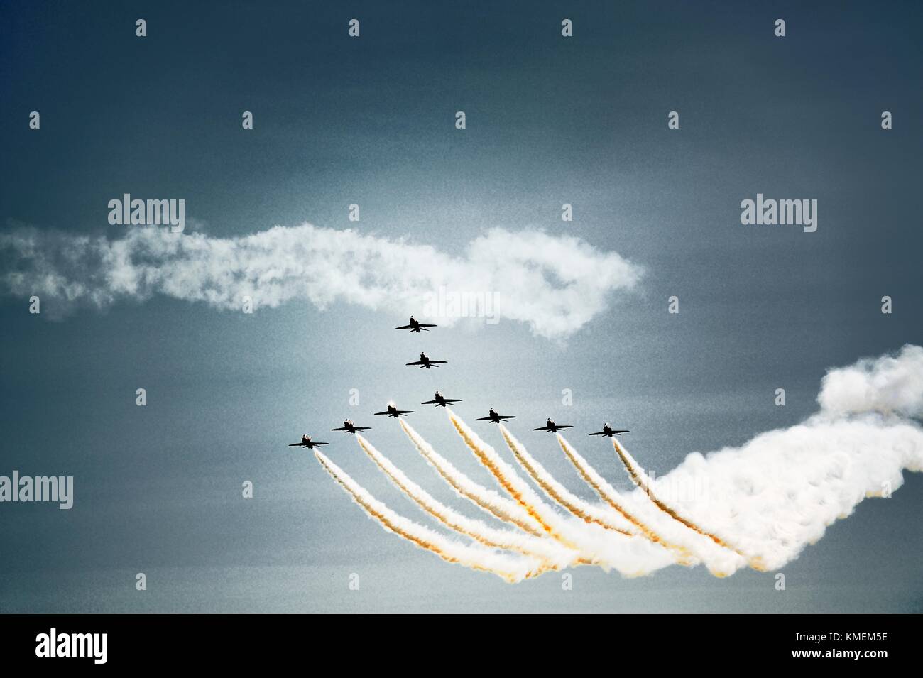 Red Arrows Royal Air Force Aerobatic Team. Complete team of nine red BAE Hawk T1As climb against blue sky Stock Photo