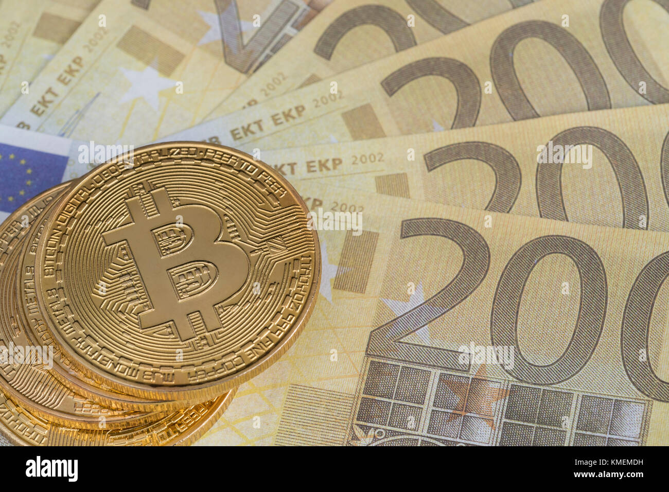 Gold-colored Bitcoin cryptocurrency with 200 Euro banknotes - Bitcoin values reaching high levels in December 2017. Stock Photo