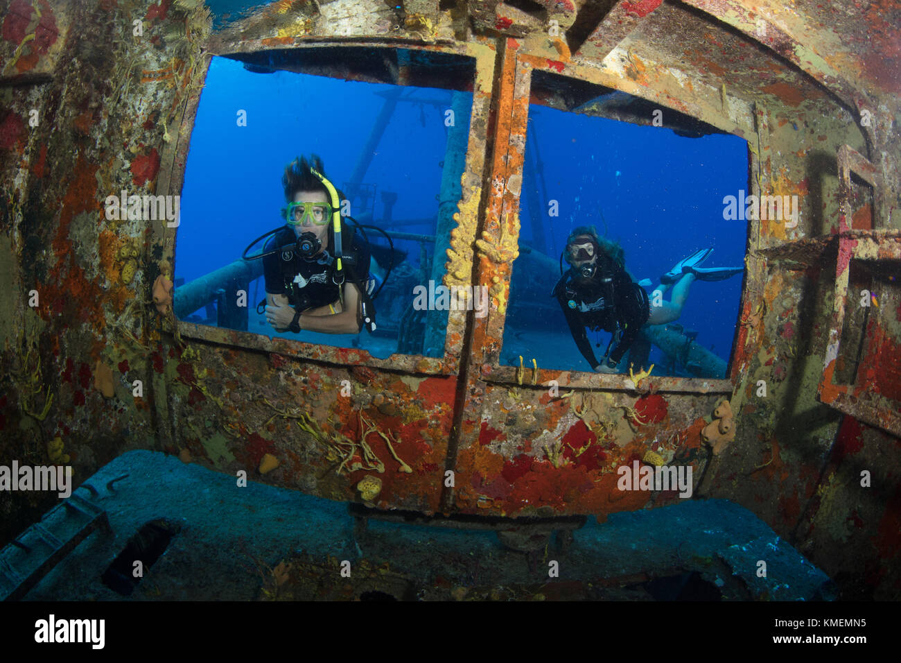 Divers peer through windows on bridge of USS Kittiwake Stock Photo