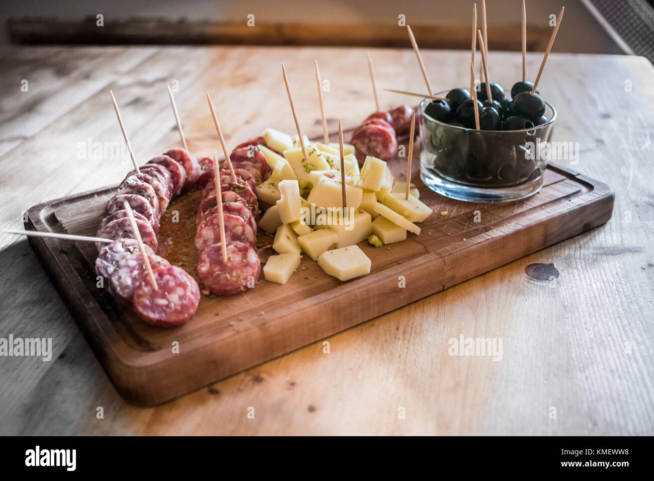 Italian appetizer served on a rustic wooden cutting board with salami