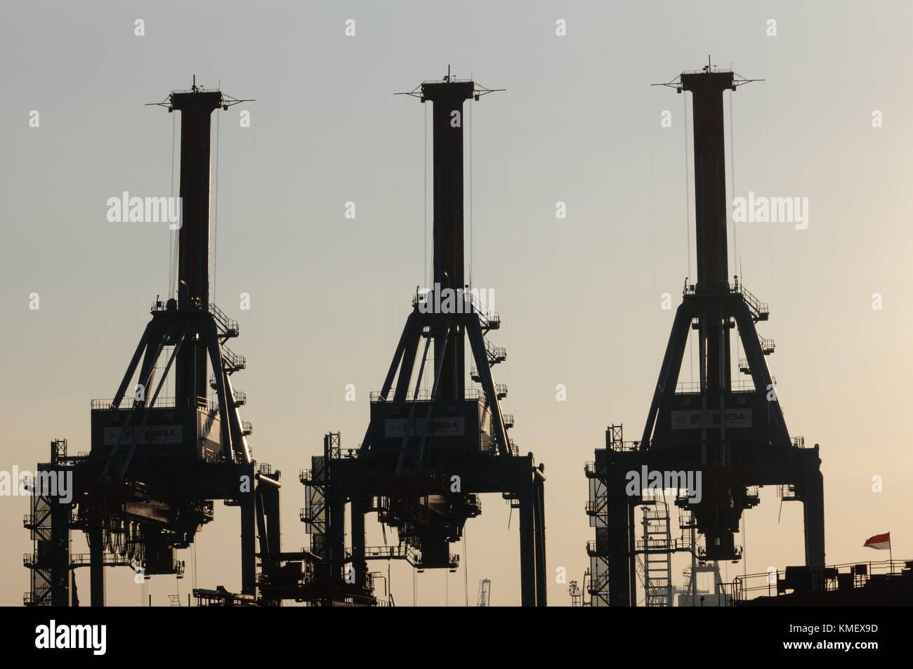 Three Container Gantry Cranes in Silhouette at Jakarta, Indonesia Stock Photo
