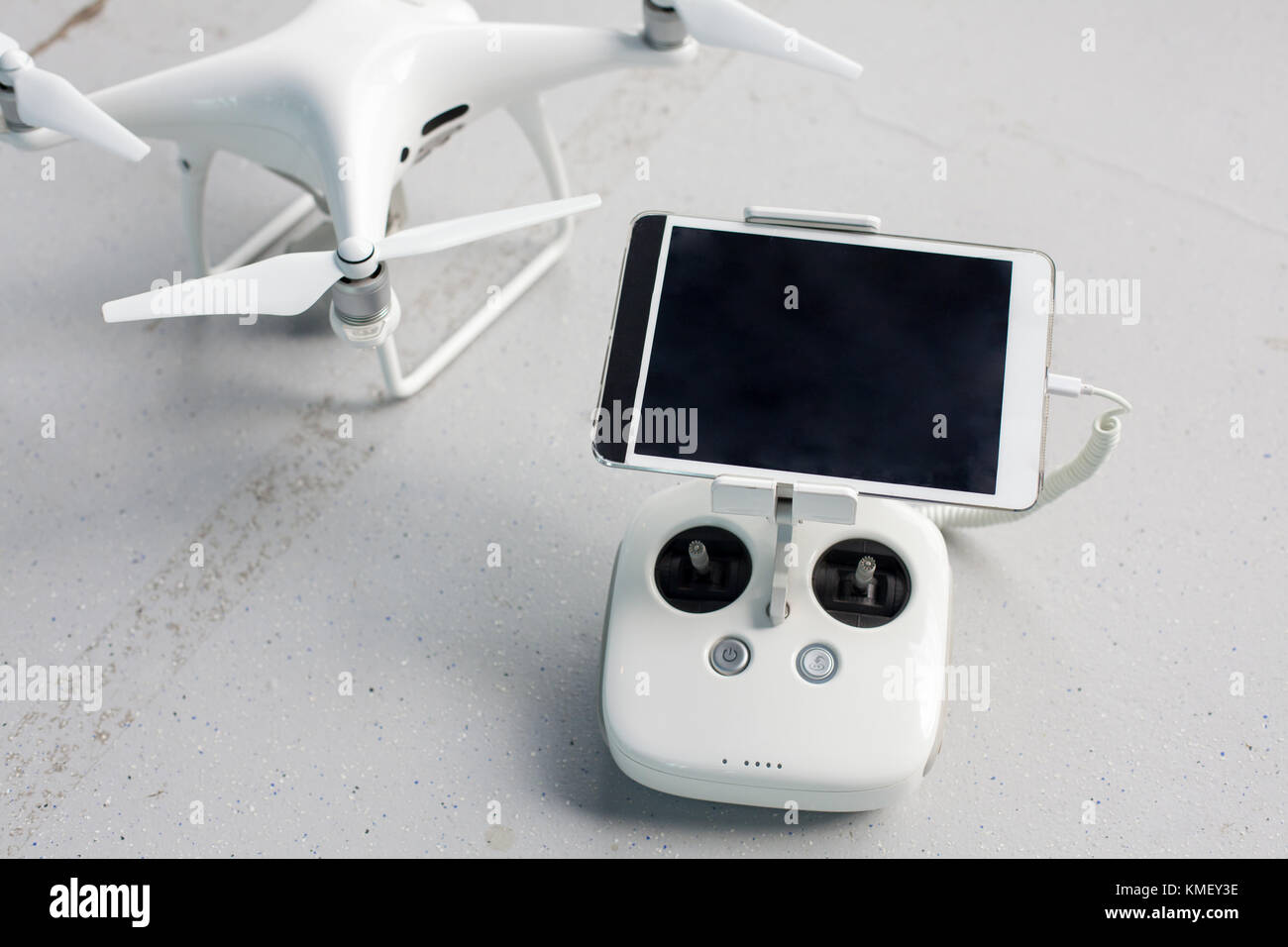 Drone with a remote control and a tablet on it on a gray concrete background. Quadcopter with camera ready to shoot video Stock Photo Alamy