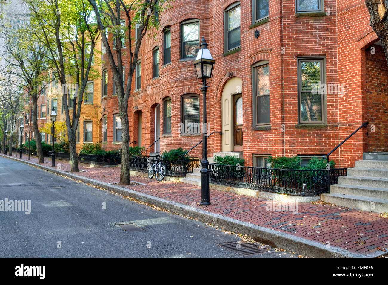 Townhouse in Back Bay, Boston. Brick apartment buildings and tree-lined street in the fall. Elegant streetscape. Stock Photo