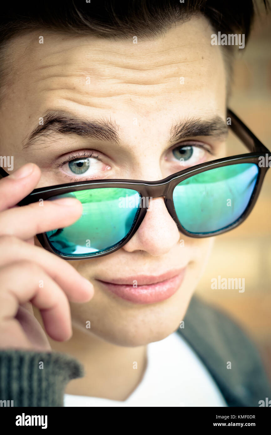 close up view of handsome millennial holding sunglasses Stock Photo