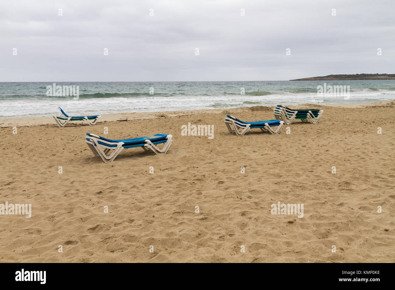 empty sunbeds, out of season, on beach on a rainy day Stock Photo