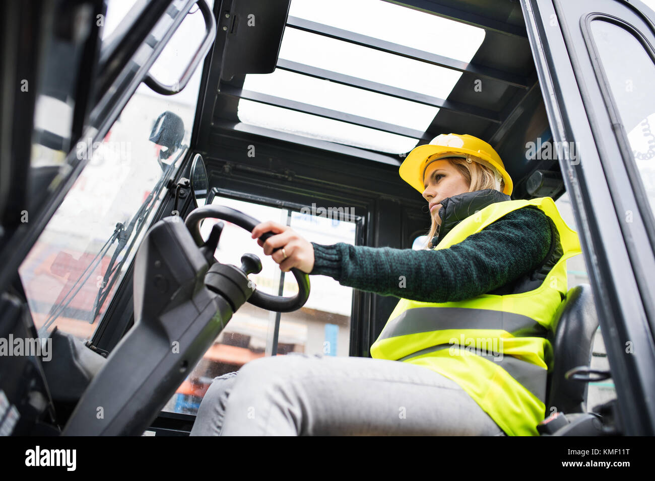 Woman forklift truck driver in an industrial area. Stock Photo