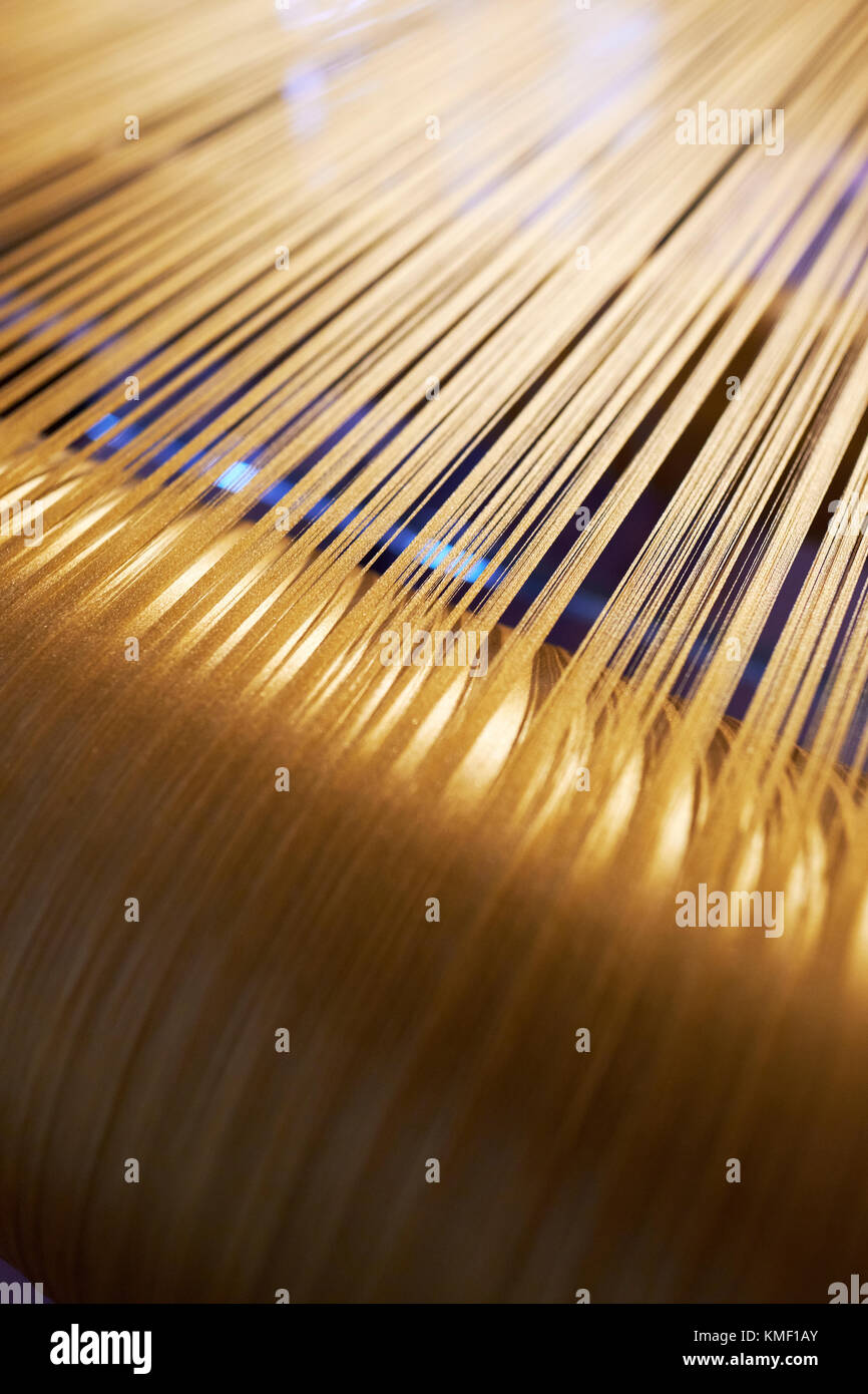 Gold textile threads on a loom. Stock Photo