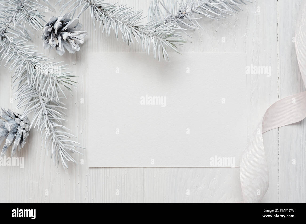 Mockup Christmas tree cone and white ribbon , flatlay on a white wooden background, with place for your text Stock Photo