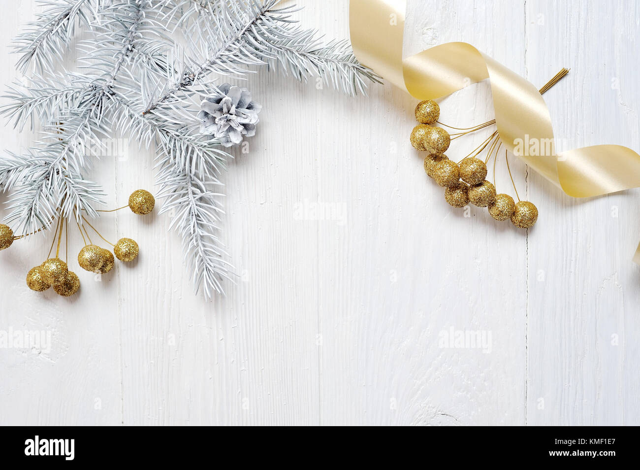 Mockup Christmas gold bow and tree cone, flatlay on a white wooden background, with place for your text Stock Photo