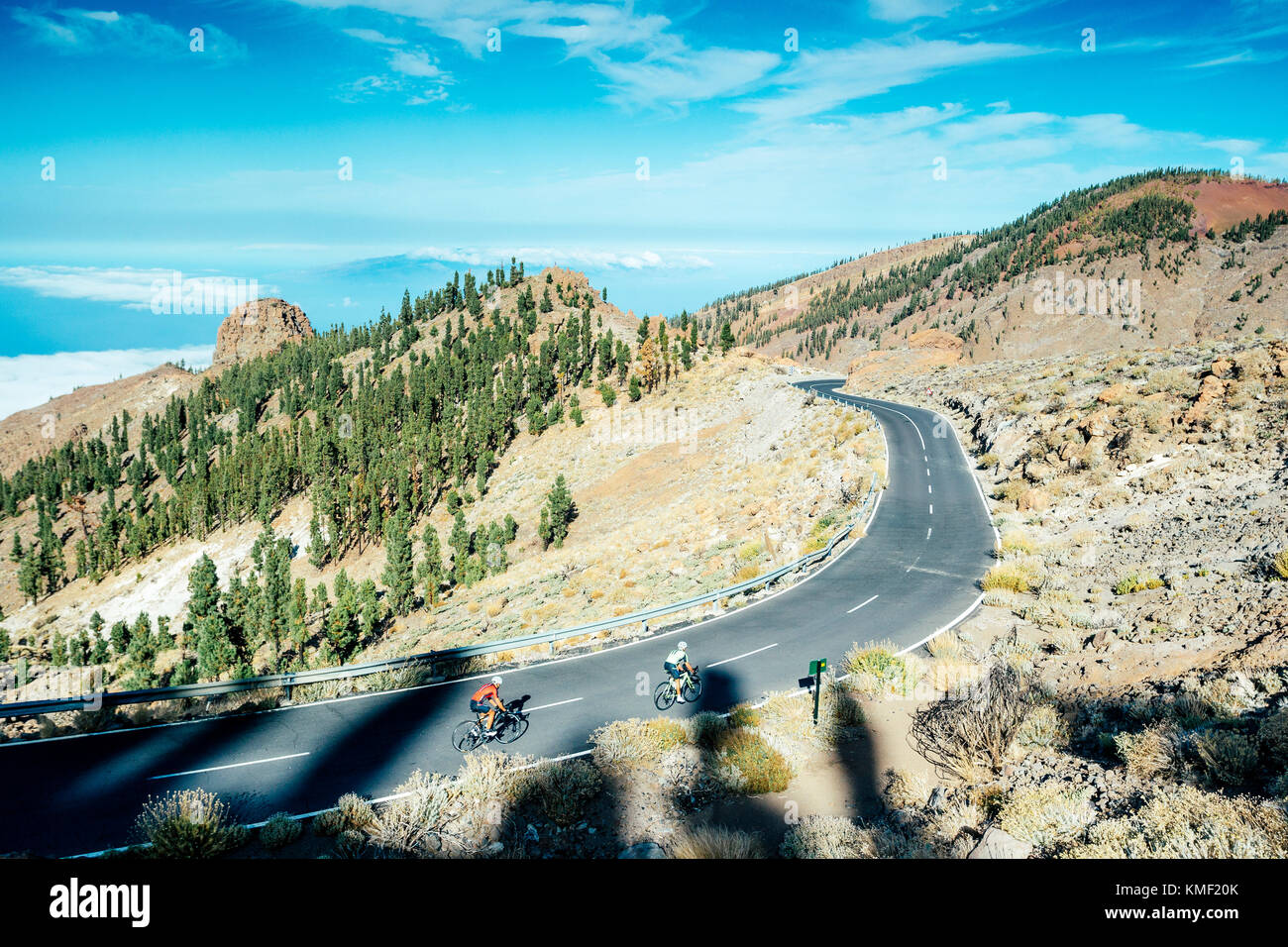 Two cyclists pedaling on mountain road,Teide National Park,Tenerife,Canary Islands,Spain Stock Photo