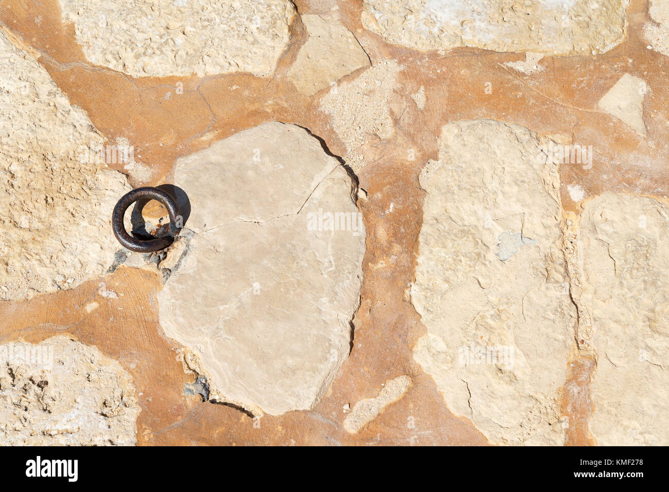 Old metal ring in the wall. The texture of the stone. Stock Photo