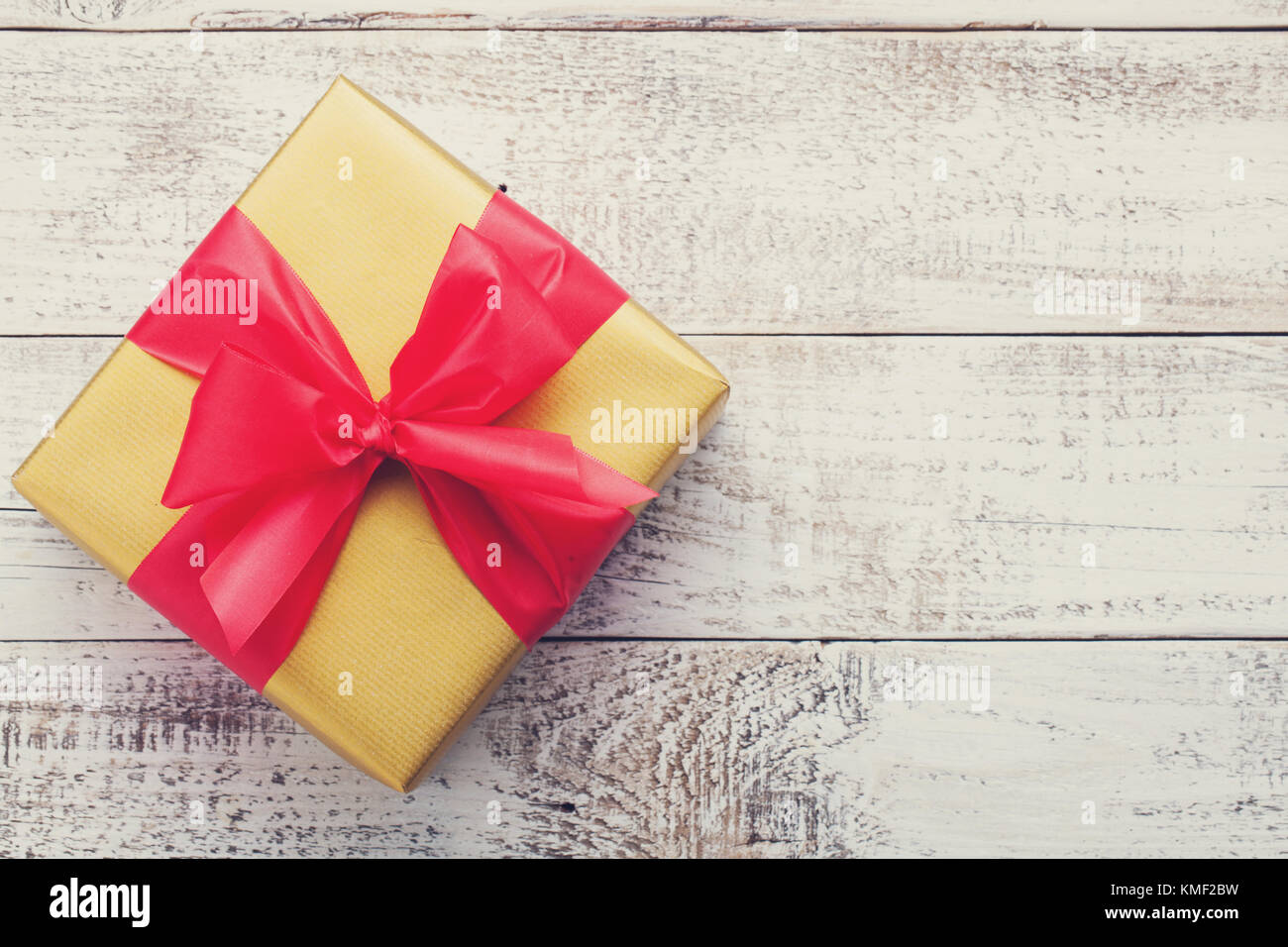 Golden gift box tied with a red ribbon isolated on white background ...