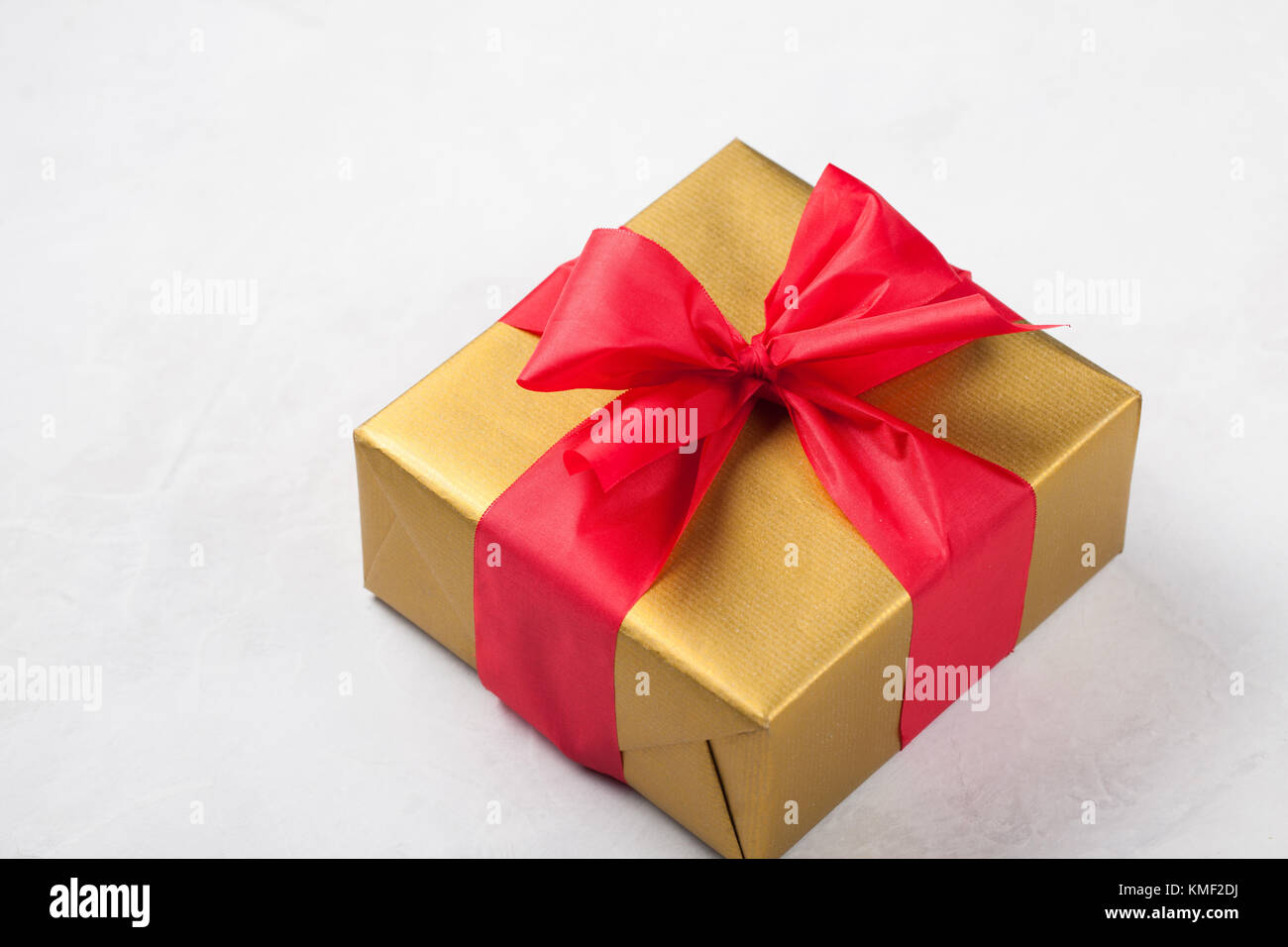 Golden gift box tied with a red ribbon isolated on white background ...