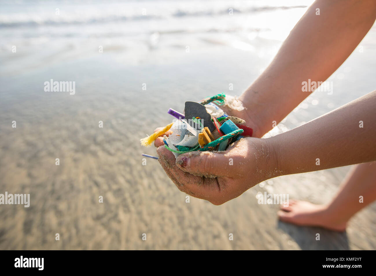 Close up of hands of girl holding plastic trash picked up at Torrey Pines State Beach in San Diego,California,USA Stock Photo