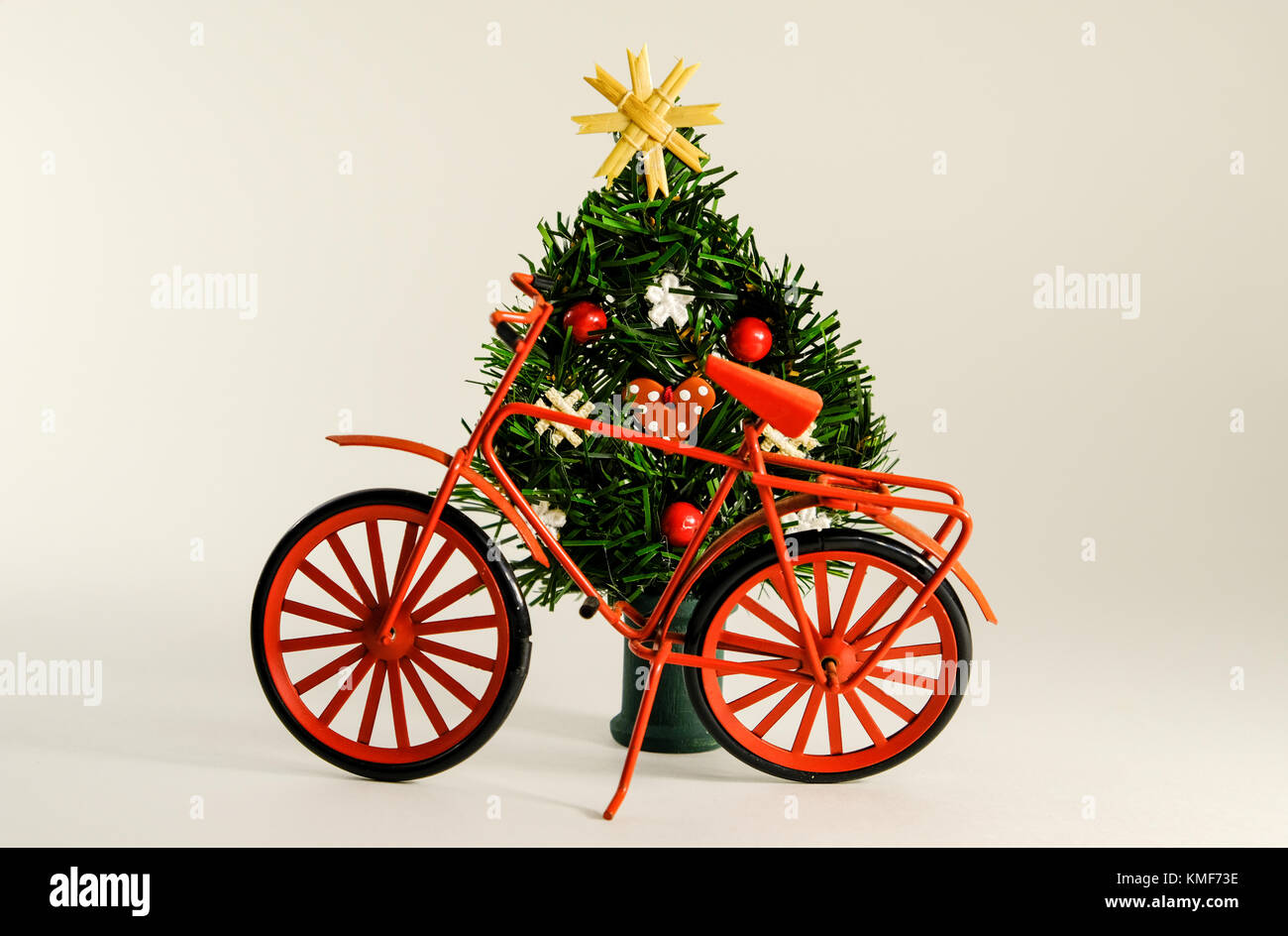 Christmas decor with an artificial Christmas tree and a tiny bike model. Stock Photo
