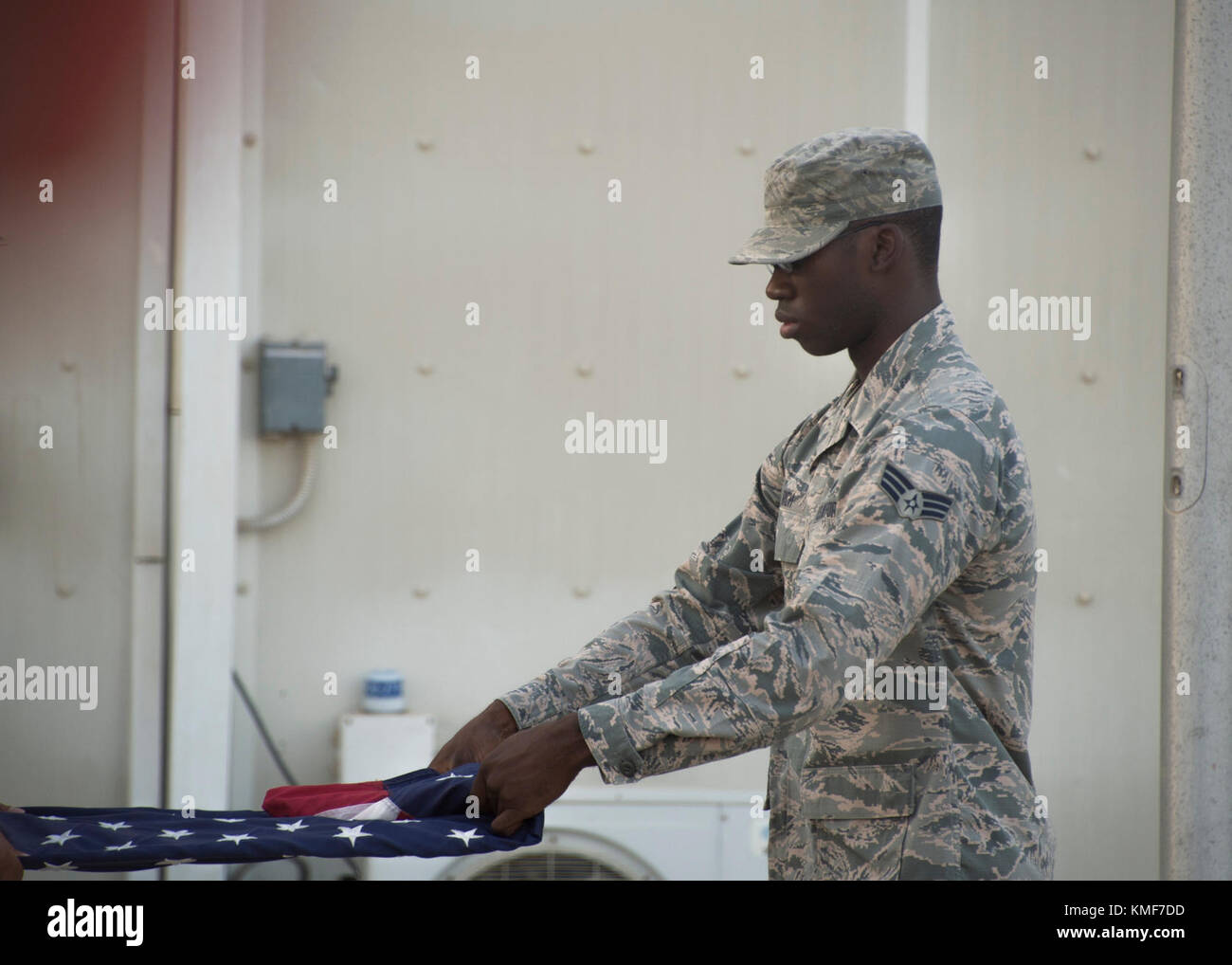 Senior Airman Rashad Rich, 380th Expeditionary Force Support Squadron personnel programs technician, folds the U.S. flag during the 380th Air Expeditionary Wing retreat ceremony, Dec. 1, 2017 Al Dhafra Air Base, United Arab Emirates. The 380th AEW holds a monthly wing-wide retreat ceremony to honor U.S. service members killed in action during the previous month. Stock Photo