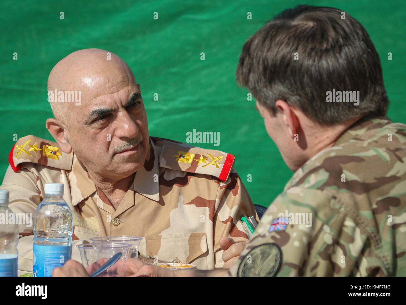Iraqi security force Staff Lt. Gen. Wa’ad Zainl Saleh, senior secretary to the Iraqi chief of defense, speaks with British Army Maj. Gen. Felix Gedney, deputy commanding general for strategy and support with Combined Joint Task Force – Operation Inherent Resolve, during a High Level Committee lunch in Baghdad, Iraq, Dec. 5, 2017. The committee discussed the way forward for the Coalition’s continued support of the Iraqi security forces. CJTF-OIR is the global Coalition to defeat ISIS in Iraq and Syria. Stock Photo