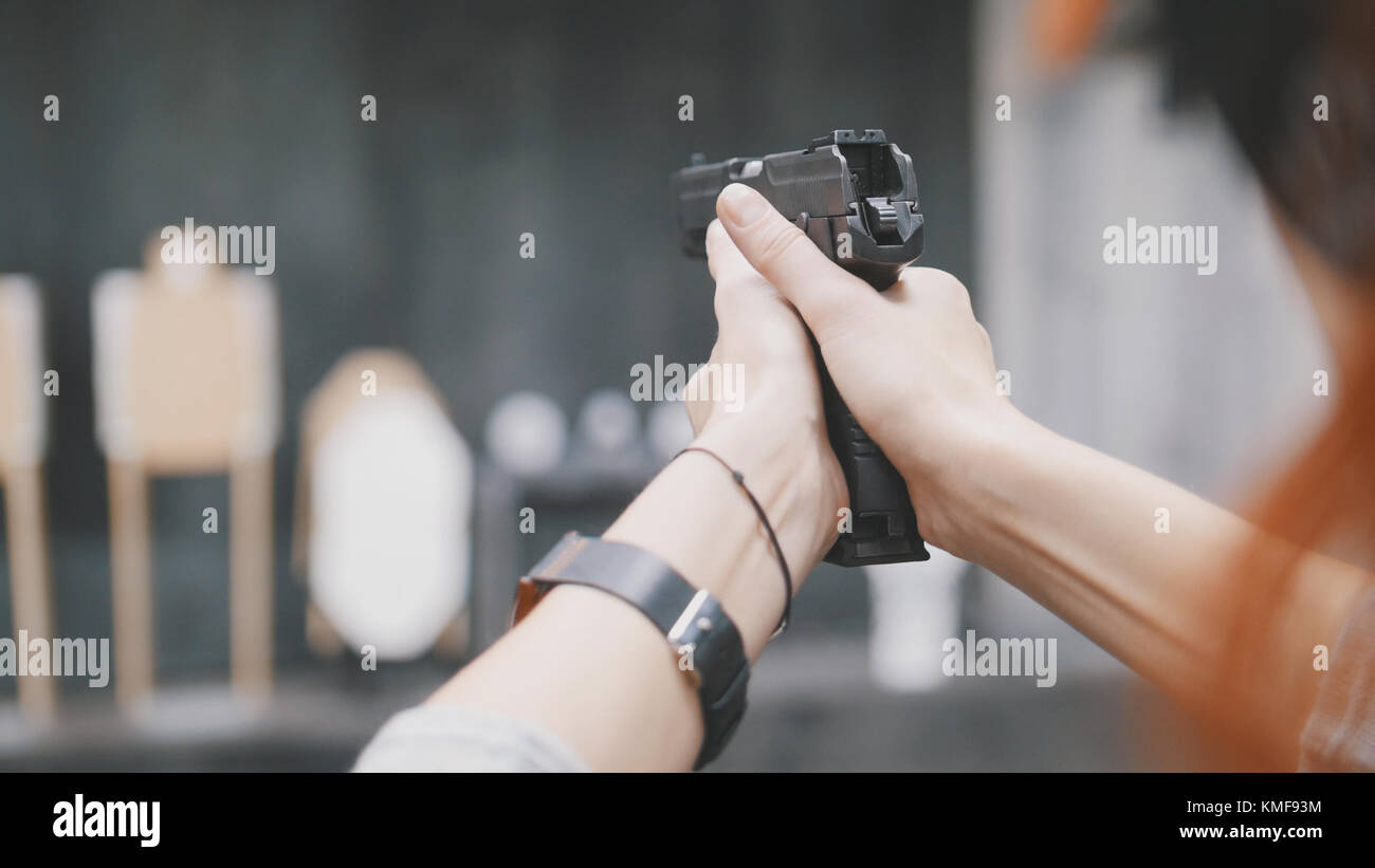 Woman shooting with a gun in shooting gallery Stock Photo Alamy
