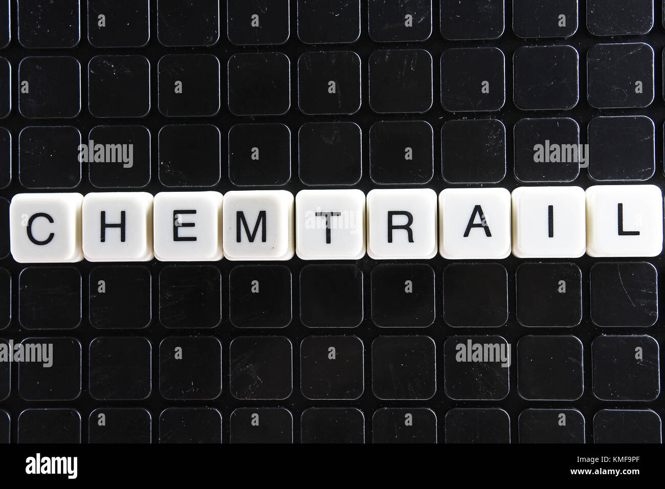 Chemtrail text word crossword. Alphabet letter blocks game texture background. White alphabetical letters on black background. White educational toy block with words. Stock Photo