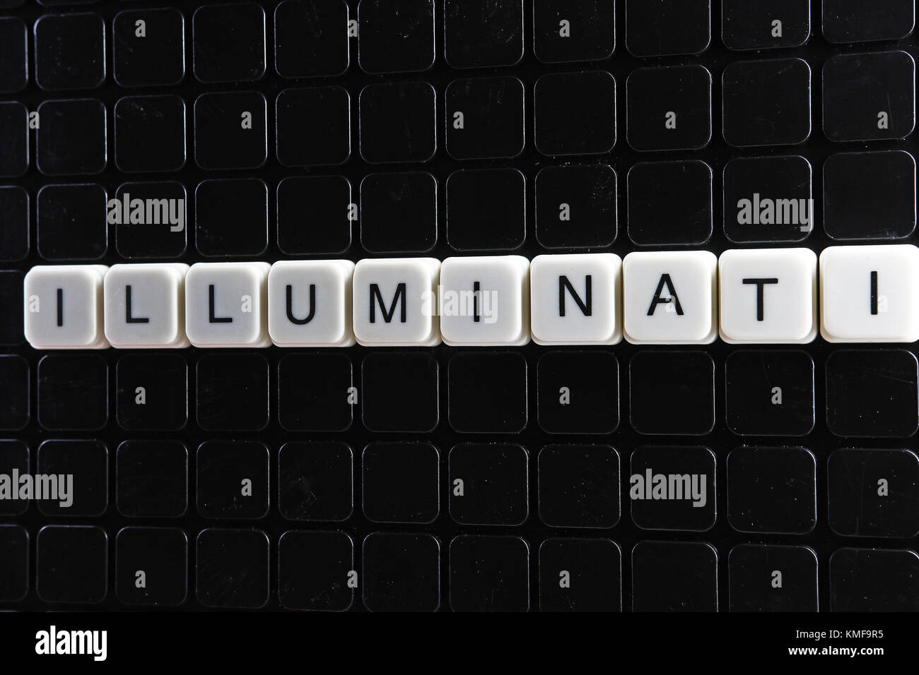 Illuminati text word crossword. Alphabet letter blocks game texture  background. White alphabetical letters on black background. White  educational toy block with words Stock Photo - Alamy