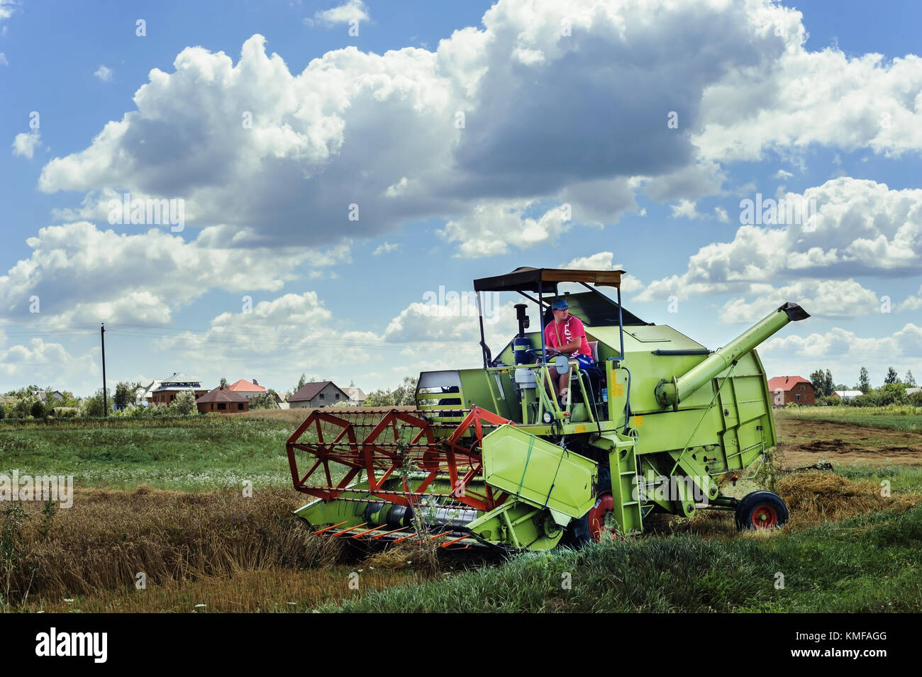 The farmer on the combine harvester is harvesting a grain. Pidhiriya. Ivano Frankivsk state. Ukraine. July 29, 2017. Stock Photo