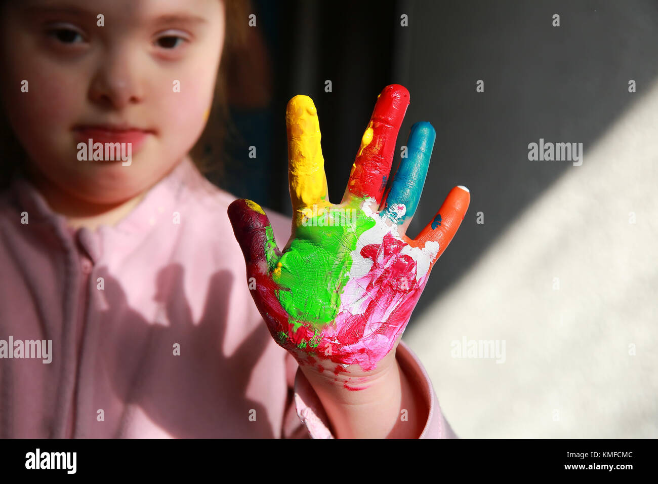 Down syndrome girl with painted hands Stock Photo