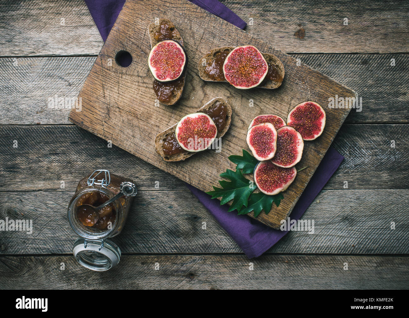 figs, nuts and bread with jam on wooden choppingboard in rustic style. Autumn season food photo Stock Photo