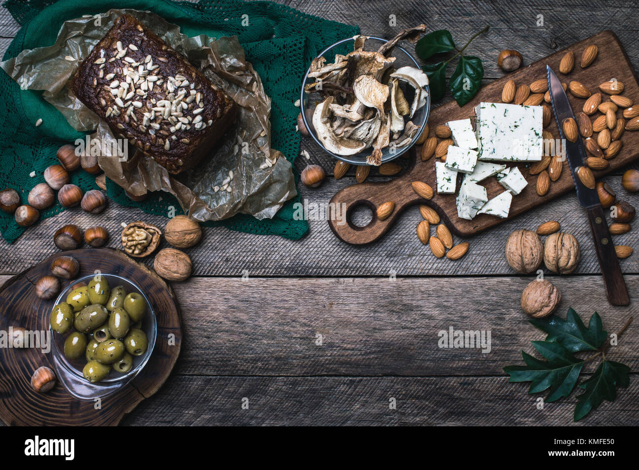 Rustic style olives, nuts mushrooms  and bread  with seeds on wood Stock Photo
