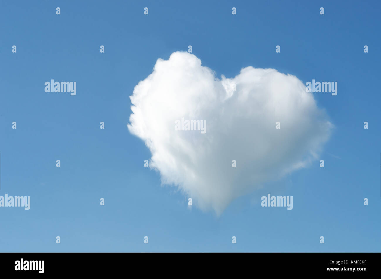 A white heart shaped fluffy cloud in an otherwise clear bright blue sky ...