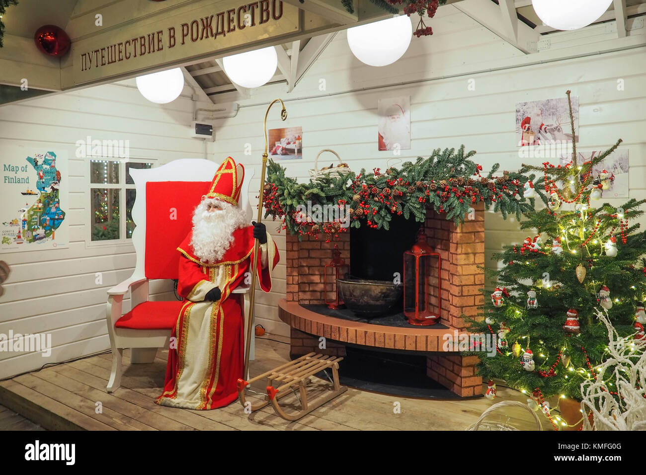 A Santa Claus in his house sitting in his big red chair near a fireplace. Stock Photo